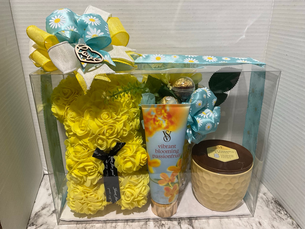 Yellow floral bear gift box with body care, candle, chocolates, flowers, and a blue daisy bow