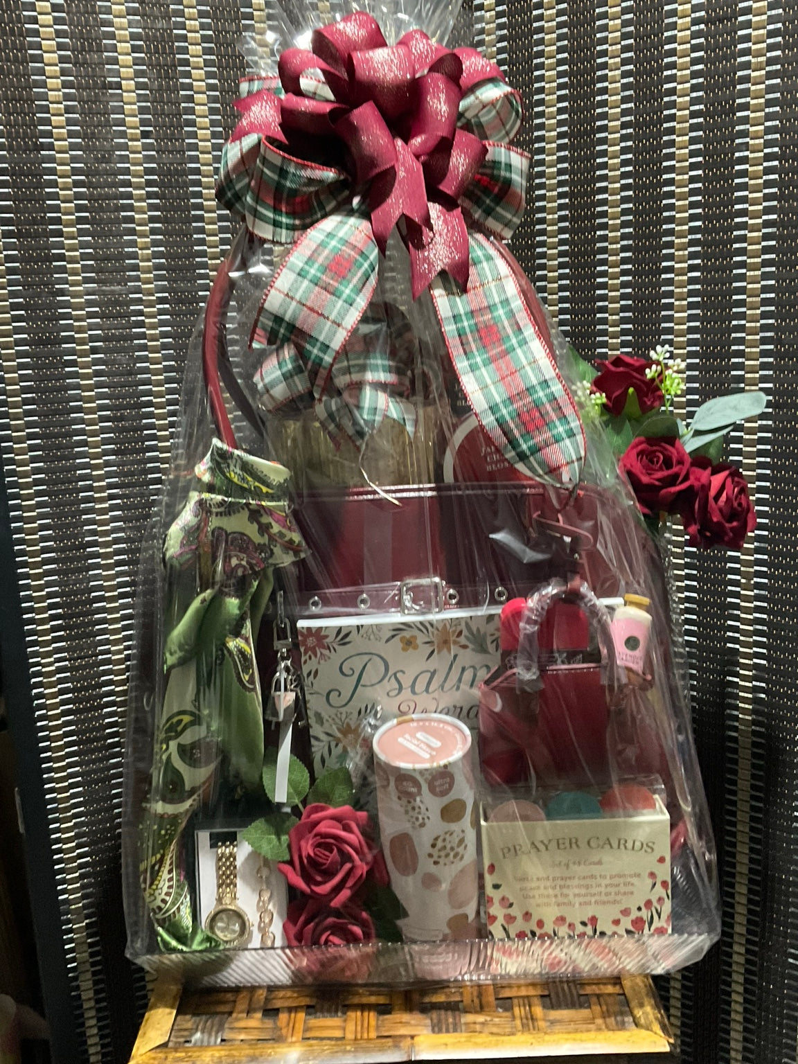 Luxury burgundy faith and wellness gift arrangement with handbags, prayer cards, scarf, watch, flowers, and self-care items