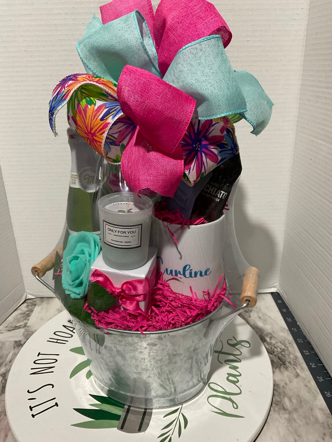 Colorful birthday gift basket with candle, tea, sparkling cider, personalized glass, flowers, and boutique bow