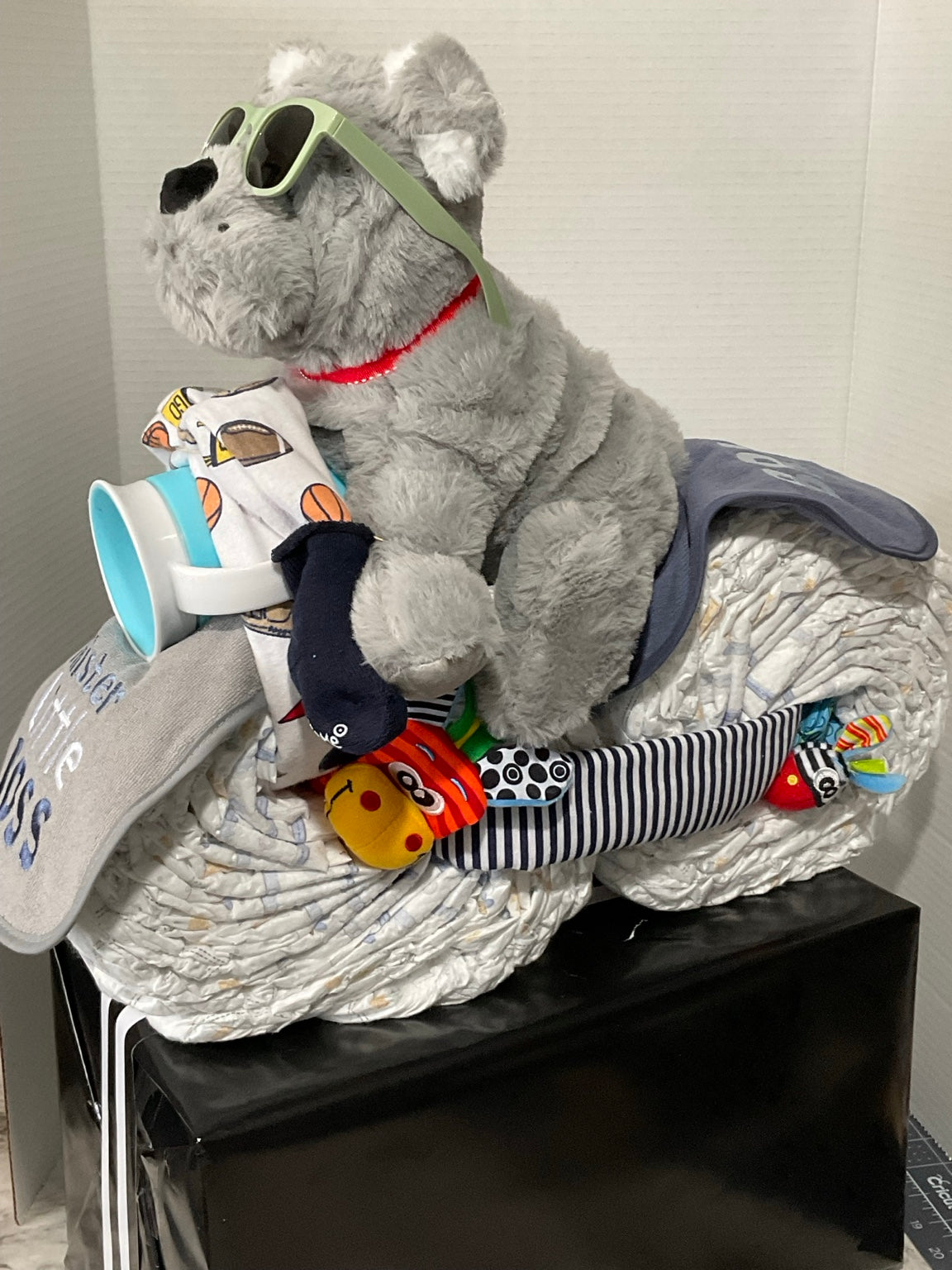 Handcrafted baby diaper motorcycle with plush dog, baby apparel, bib, toys, and personalized details